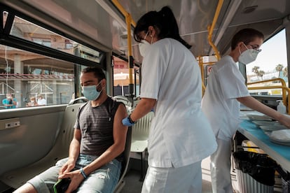 A man getting vaccinated inside the 'Vacuguagua,' a medical bus driving through the villages of Gran Canaria in search of people who have yet to get their shots. 