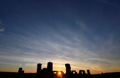 El sol sale entre las piedras del megalítico monumento de Stonehenge durante la celebración del solsticio de verano, en Salisbury (Reino Unido).