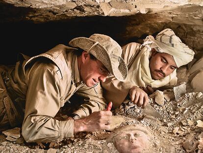 El egiptólogo José Manuel Galán desentierra, junto al trabajador especializado Omar Farouk, una máscara de ataúd en un pozo funerario.