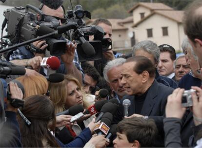 Berlusconi habla con la prensa en la inauguración del curso escolar en tiendas de campaña en una localidad afectada por el terremoto.