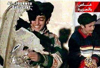 Hamza Bin Osama Bin Laden (a la izquierda), hijo del líder de Al Qaeda, juega con los restos de un helicóptero de EE UU. La imagen es de televisión.