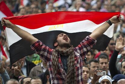 Un joven egipcio muestra la bandera nacional, mientras grita consignas contra el presidente Mubarak, el 11 de febrero de 2011, en la plaza Tahrir de El Cairo.