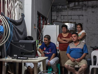 Familiares de los cinco desaparecidos en Tierra Blanca, frente al televisor.