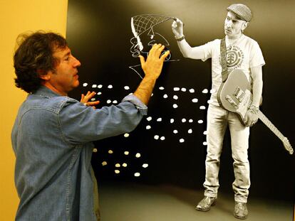 Juan Torre posa junto a la fotografía que ha realizado del músico Fito Cabrales, ayer en su muestra en Bilbao.