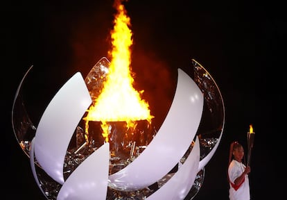La tenista japonesa Naomi Osaka enciende la llama olímpica, este viernes en Tokio.