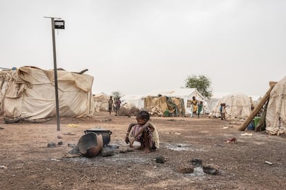 Una niña, frente a una cacerola puesta sobre el fuego en un campo de desplazados por la violencia en Barsalogho, Burkina Faso.