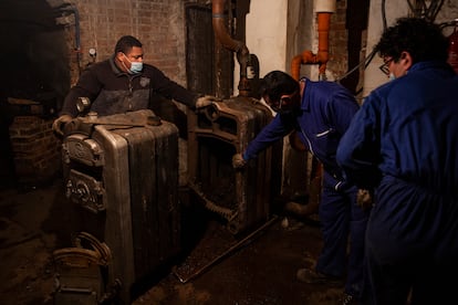 Reparación de una de las últimas calderas de carbón que hay en Madrid, en la calle Dos Hermanas.