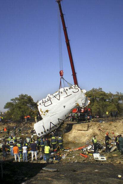 Una grúa levanta parte del fuselaje del avión siniestrado en Barajas el 20 de agosto de 2008.