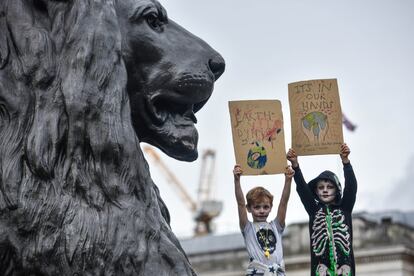 Dos niños muestran sus pancartas en Trafalgar Square, Londres (Reino Unido). 