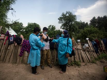 Dos sanitarios administran vacunas de AstraZeneca en Minnar, localidad la norte de Srinagar, India, este jueves.