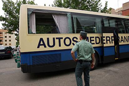 Un guardia civil, ante la ventanilla rota del autobús tiroteado en Castellón.