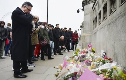 Numerosas personas observan las flores colocadas cerca de la escena del atentado de Londres.