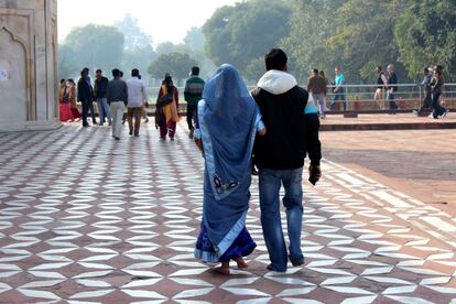 Una pareja camina alrededor del Taj Mahal en Agra. La vestimenta tradicional de la joven contrasta con la del hombre, mucho más occidental.