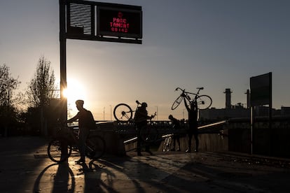 Un grupo de ciclistas saltan la valla de acceso al parque fluvial del Besòs para entrar a pedalear antes de su apertura