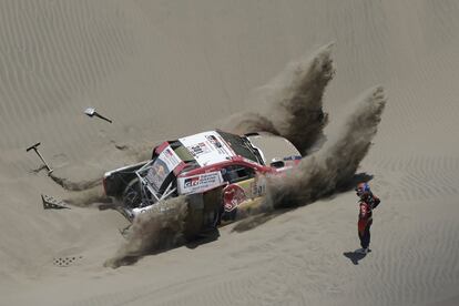 El copiloto Matthieu Baumel de Francia observa mientras el piloto Nasser Al-Attiyah de Qatar, intenta sacar de la arena su Toyota durante la cuarta etapa del Rally Dakar 2018 en San Juan de Marcona (Per), el 9 de enero de 2018.