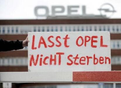 Un trabajador sujeta un cartel en el que dice "No dejen morir a Opel", en las puertas de la factoría de Bochum (Alemania).