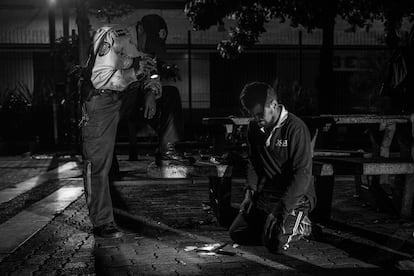 Um policial acaba de prender um suspeito que esfaqueou outro para roubá-lo.