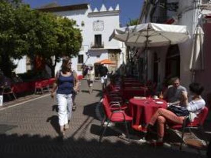 Algunos turistas se refrescan sentados en una terraza de la plaza de los Naranjos, en Marbella (Málaga). EFE/Archivo