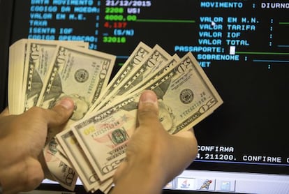 Un agente de un banco cuenta billetes de dólar