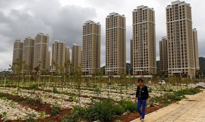 Un campesino pasea frente a un complejo residencial de Kumming (provincia de Yunnan, sur de China).