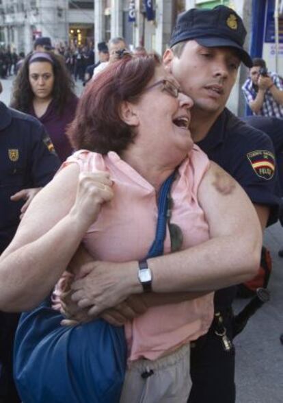 La policía desaloja de Sol a una participante en la protesta.