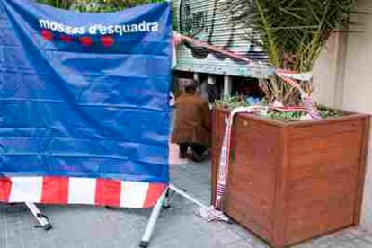 Agentes de los Mossos d' Esquadra buscan pruebas en el interior del bar Joan de Barcelona, donde se ha producido un doble crimen