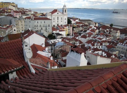 Tejados de Alfama desde el Mirador de Santa Lucía, en Lisboa. Al fondo, el Tajo