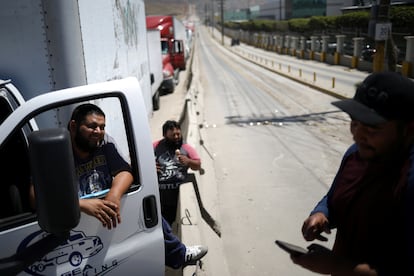 Los camioneros conversan mientras esperan en una larga fila para que el control fronterizo de aduanas cruce a los EE UU, en Tijuana, México, en 2019.