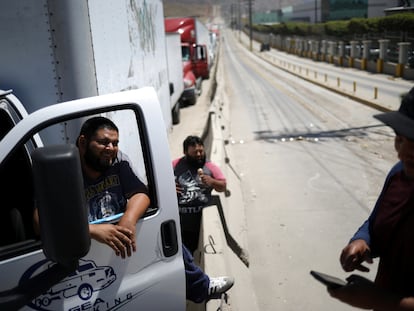 Los camioneros conversan mientras esperan en una larga fila para que el control fronterizo de aduanas cruce a los EE UU, en Tijuana, México, en 2019.