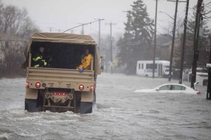 Elementos de la Guardia Nacional auxilian a personas atrapadas por las inundaciones debido a la fuerte tormenta en Quincy, Massachusettss.