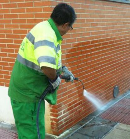 Un operario limpia la sangre de la víctima de la calle.