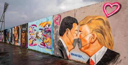 Vista de un mural del presidente estadounidense Donald Trump (D) y el presidente chino Xi Jinping besándose usando mascarillas en el Parque del Muro de Berlín.