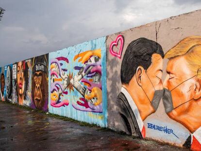Vista de un mural del presidente estadounidense Donald Trump (D) y el presidente chino Xi Jinping besándose usando mascarillas en el Parque del Muro de Berlín.
