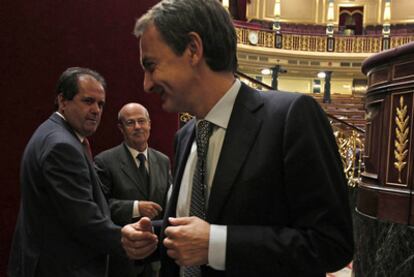 Zapatero charla con el diputado de CC José Luis Perestelo (en primer término) y el socialista canario José Segura en el Congreso.