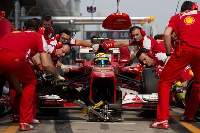 Los mecánicos de Ferrari examinan el bólido de Felipe Massa durante los entrenamientos.