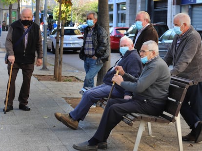 Un grupo de hombres portan mascarilla en la calle.