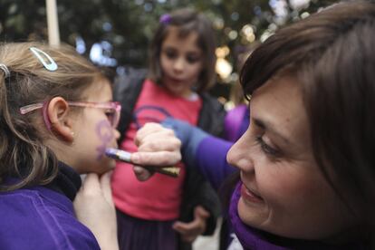 Una madre del colegio publico Nuestra señora de la Paloma se reúne con otras madres y padres frente al colegio para ir juntos a la manifestación del 8M, el 8 de marzo de 2019, en Madrid.