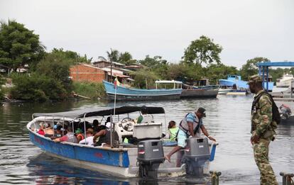 Migrantes saliendo en lanchas hacia Capurgan&aacute; en el muelle El Waffe, en Turbo.