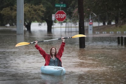 Jovem usa caiaque para se deslocar em Houston após passagem do furacão Harvey.