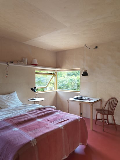 El dormitorio de Barbara, panelado de chapa de abedul, tiene una ventana en esquina. El escritorio es un prototipo construido por su suegro, y la mesilla de noche, un diseño de Søstrene Grene, al igual que la lamparilla.