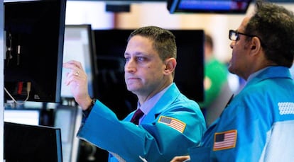 Varios trabajadores de la Bolsa contemplan los indicadores de mercado en una pantalla en Nueva York (Estados Unidos).