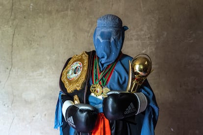 An Afghan mixed martial arts fighter poses with her trophies in Kabul. Beatings from parents and ridicule from neighbors were not enough to intimidate these athletes, who wanted to practice the sport they loved. After the arrival of the Taliban, they say they are not the same people.