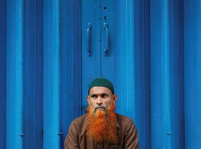 Un hombre espera en la puerta de un mercado antes de que haya abierto en Colombo (Sri Lanka).