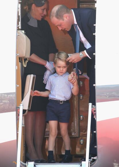 Mientras, el príncipe Guillermo de Inglaterra, duque de Cambridge, se encarga de su hijo, el príncipe Jorge, vestido con una camisa de rayas de manga corta y unos pantolones marinos, también cortos.