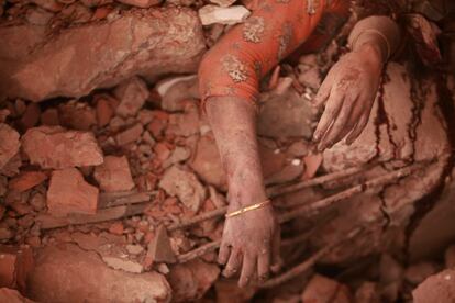 El cadáver de una joven asoma entre los escombros del edificio que se derrumbó el miércoles en Dacca (Bangladehs), 26 de abril de 2013.