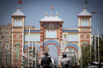 Dos jinetes a caballo se dirigen hacia la portada de la feria, el martes en Sevilla.