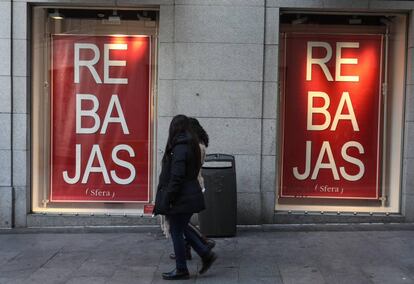 Dos mujeres pasan por delante de un escaparate de un establecimiento donde se anuncia la campaña de rebajas.