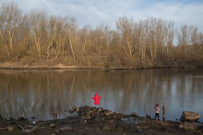 Niños migrantes observan Grecia desde la orilla turca del río Evros, frontera natural entre ambos países, en marzo de 2020.