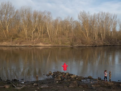 Niños migrantes observan Grecia desde la orilla turca del río Evros, frontera natural entre ambos países, en marzo de 2020.