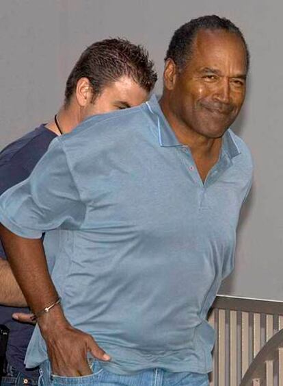 O. J. Simpson es conducido, esposado, tras su detención en Las Vegas por robo a mano armada.